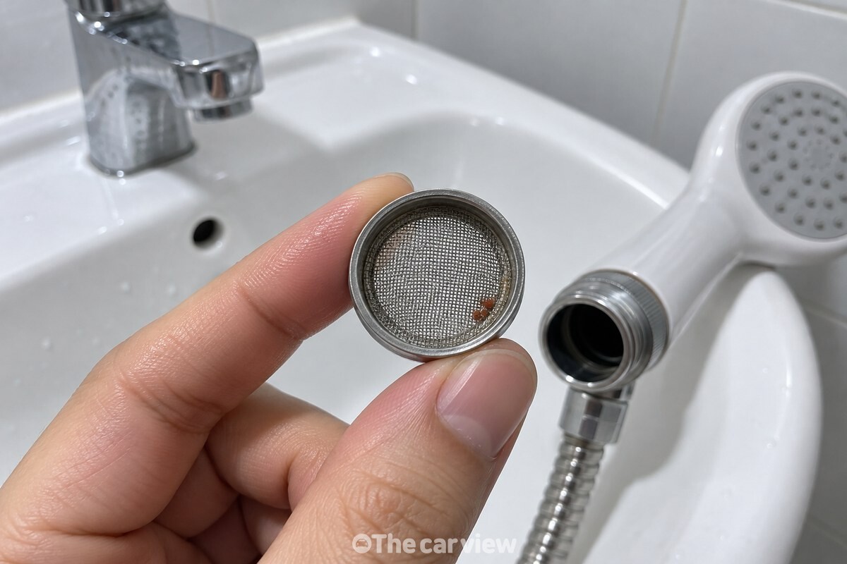 분리한 샤워기 연결부에서 꺼낸 작은 거름망의 망면을 가까이 보여주는 모습. / 기사 이해를 돕기 위한 생성형 이미지