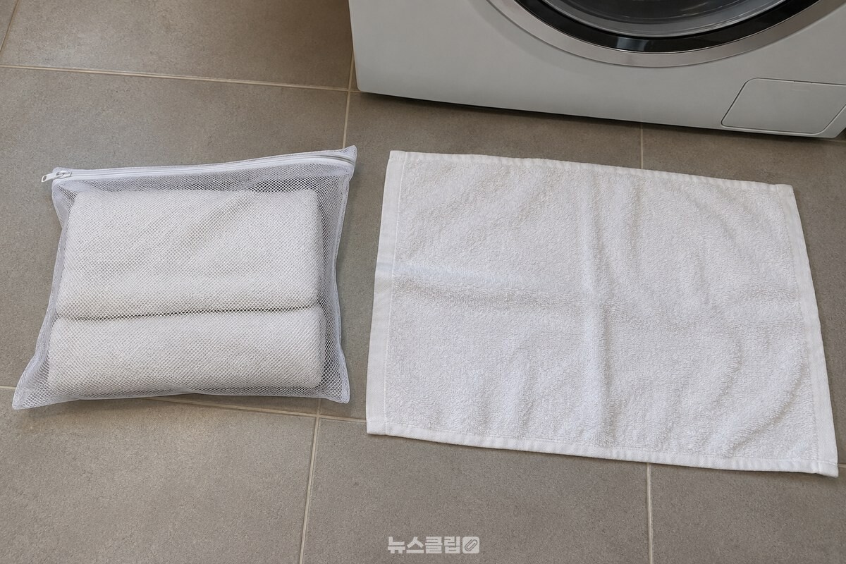 작은 흰 빨래망 안에 수건이 겹쳐 들어 있고 옆에 펼친 수건이 놓인 모습 / 기사 이해를 돕기 위한 생성형 이미지