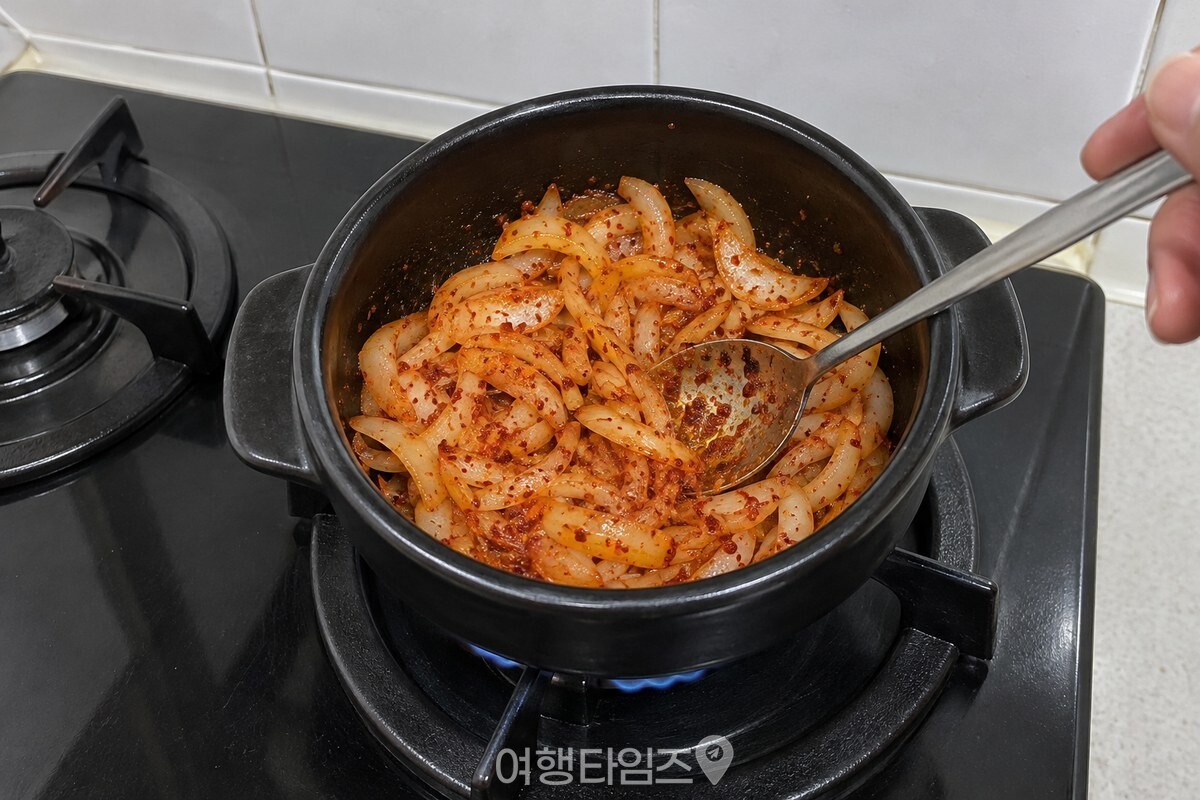 투명해진 양파와 고춧가루를 약한 불에서 볶는 뚝배기 안 모습. / 기사 이해를 돕기 위한 생성형 이미지