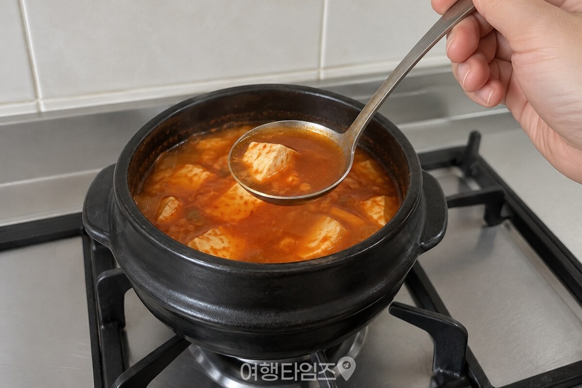불을 끈 순두부찌개 국물을 작은 국자로 떠 간을 확인하는 모습. / 기사 이해를 돕기 위한 생성형 이미지