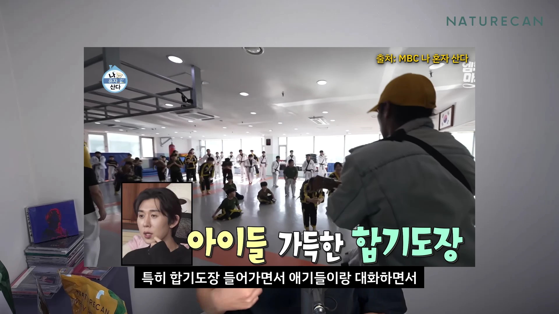 실내 합기도장에서 아이들이 도복을 입고 앉아 있고, 화면 왼쪽 하단에 작은 사각형 안에 남성이 진지한 표정으로 이야기하는 모습이 담긴 방송 영상 캡처 화면입니다.