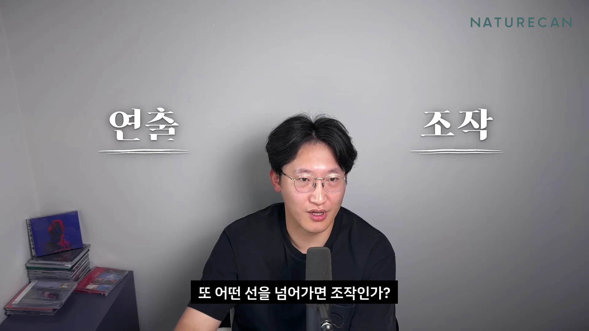 안경을 쓴 남성이 마이크 앞에 앉아 이야기하고 있으며 화면 상단 양쪽에는 연출과 조작이라는 글자가 쓰여 있습니다.