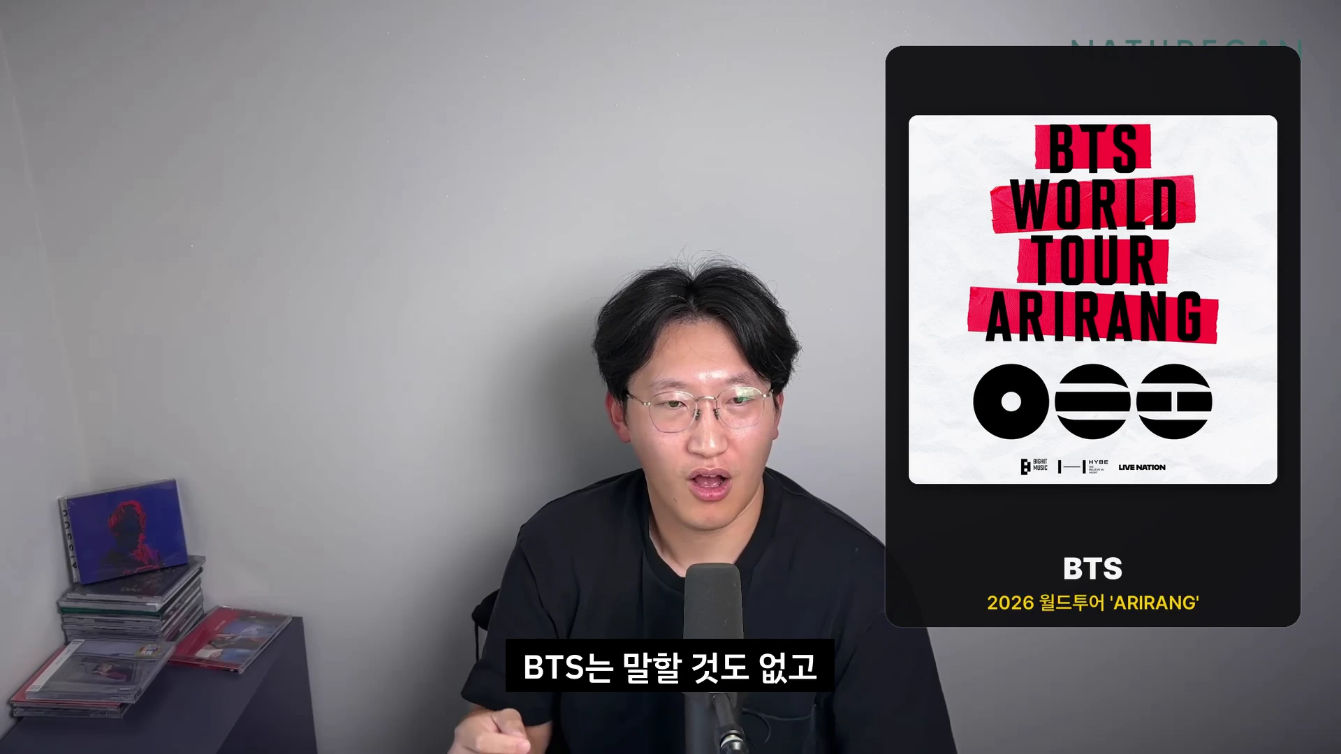 안경을 쓴 남성이 마이크 앞에서 이야기하고 있고, 화면 오른쪽에는 'BTS WORLD TOUR ARIRANG'이라고 적힌 공연 포스터 그래픽이 떠 있습니다.