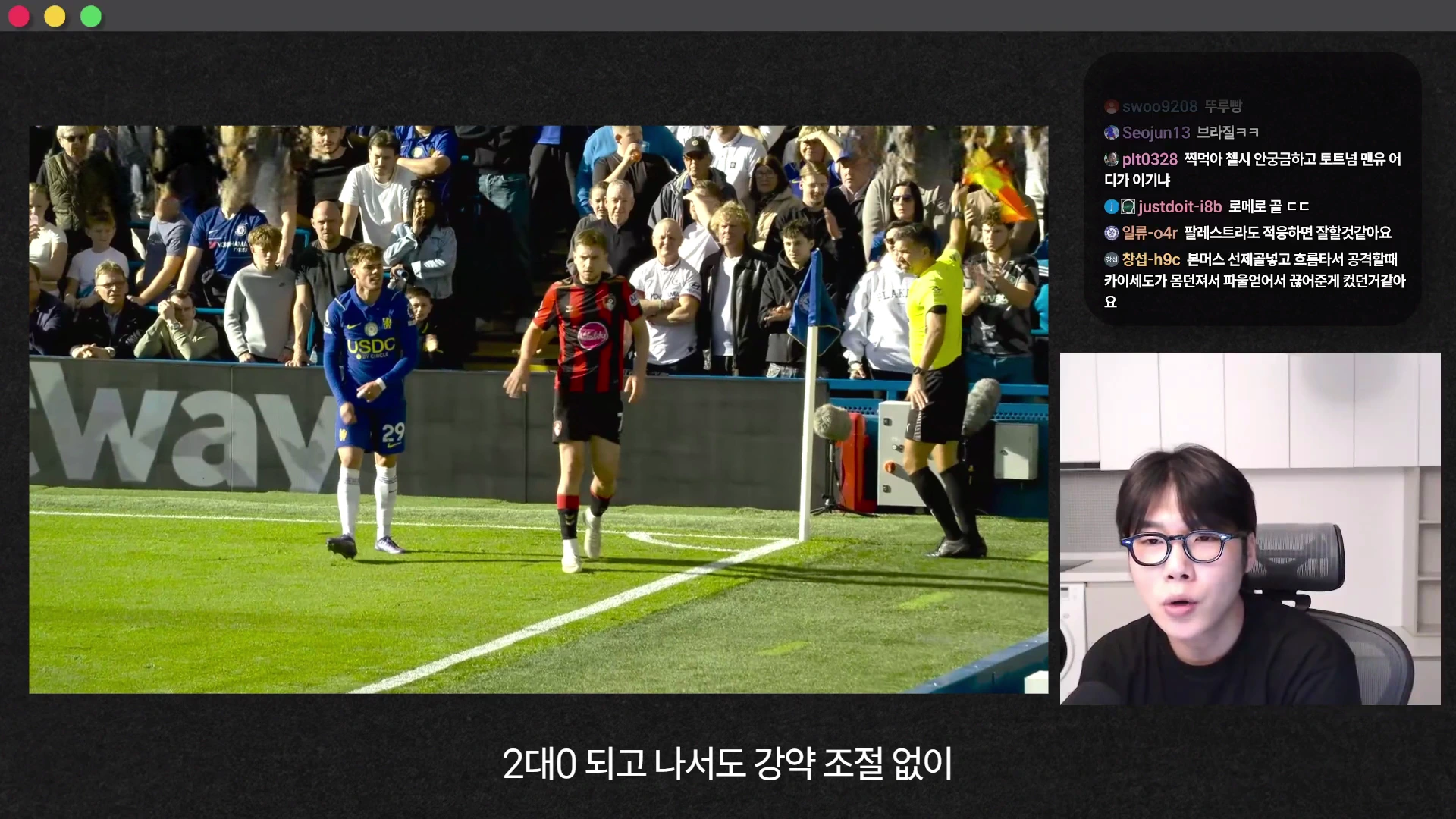 축구 경기장에서 선수가 코너킥을 준비하는 모습이 담긴 화면과 이를 설명하는 안경 쓴 남성의 영상이 분할 화면으로 배치되어 있습니다.