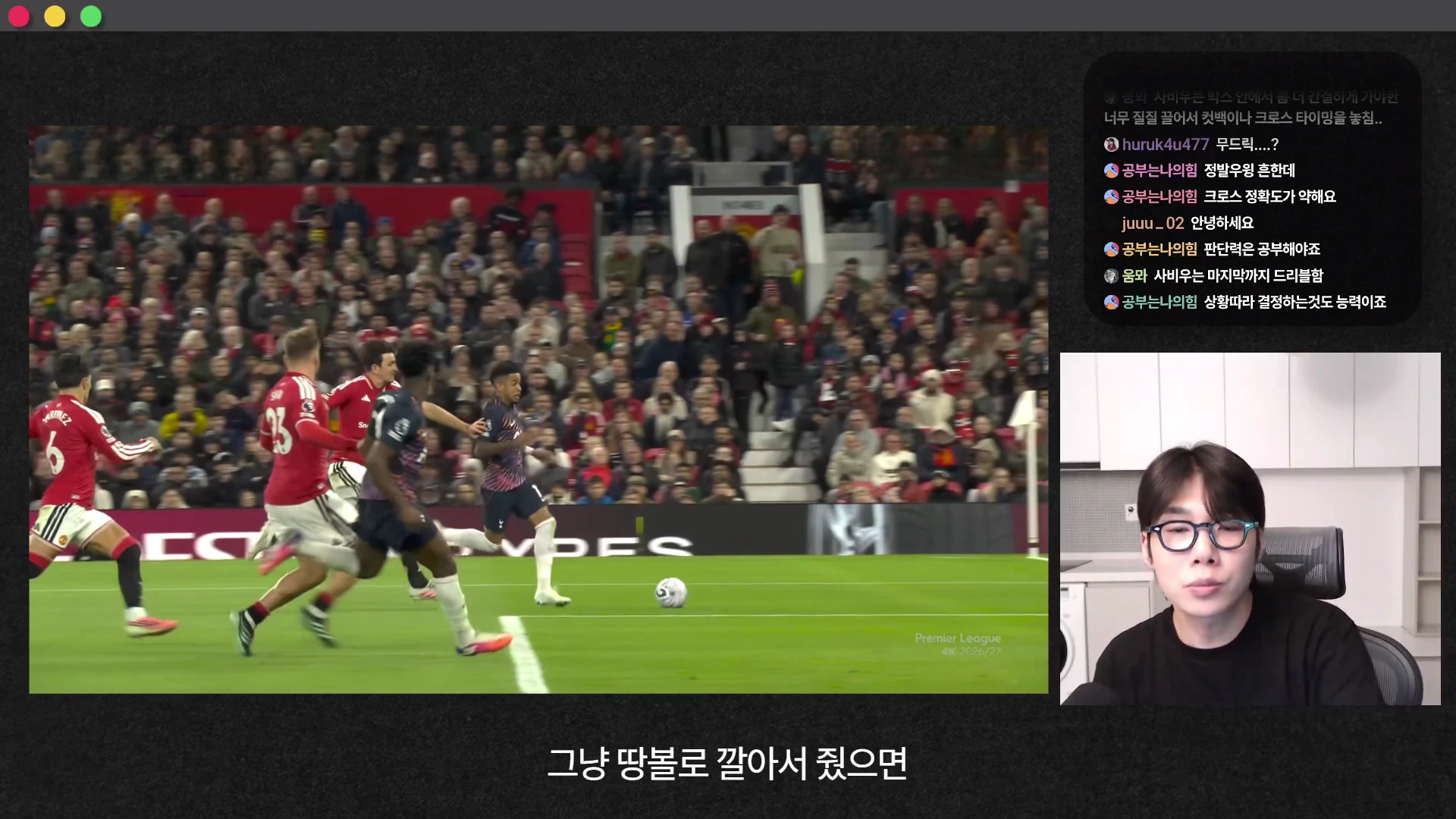 축구 경기 영상과 안경을 쓴 분석가가 화면에 보이는 유튜브 콘텐츠 화면. 왼쪽 영상에서는 공격수가 공을 몰고 상대 수비진과 대치하고 있으며, 오른쪽에는 분석가의 얼굴과 실시간 채팅창이 위치해 있습니다.