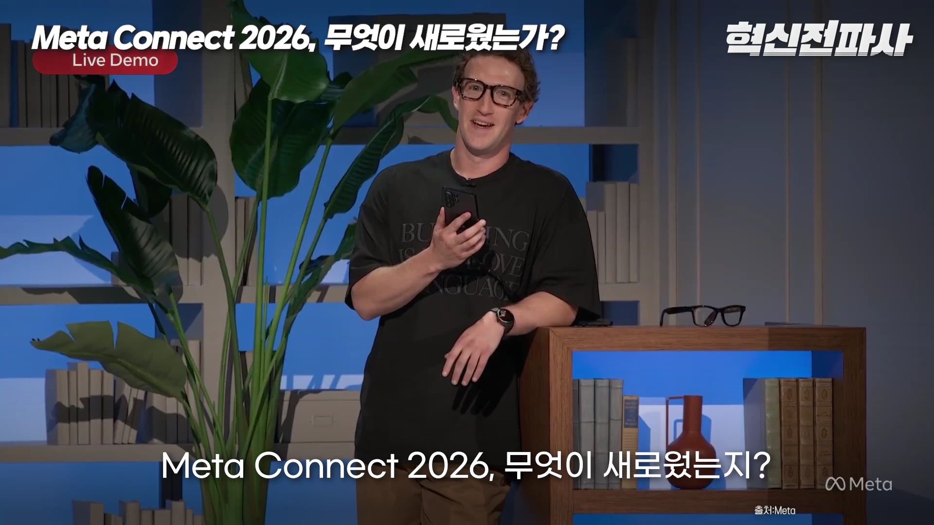 마크 저커버그가 검은색 티셔츠를 입고 안경을 쓴 채 서서 스마트폰을 들고 발표하는 모습이 담긴 메타 커넥트 2026 행사의 영상 캡처 화면입니다.