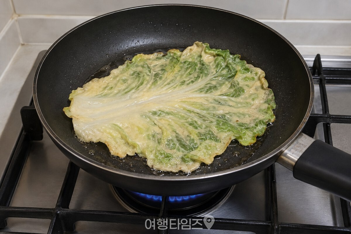 얇은 반죽을 입힌 배춧잎이 기름을 두른 팬에서 익고 있다. / 기사 이해를 돕기 위한 생성형 이미지