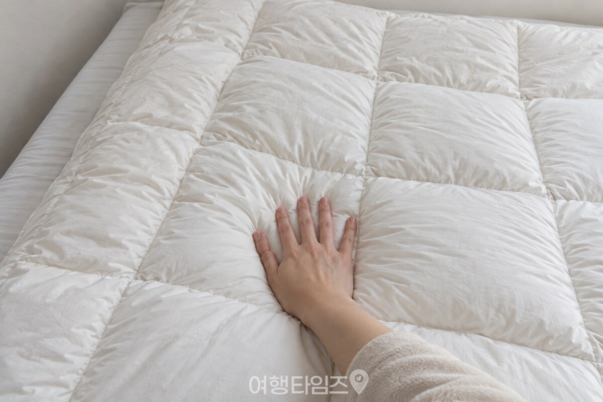 이불커버를 벗긴 겨울 이불의 고른 속솜 두께가 침대 위에서 보인다. / 기사 이해를 돕기 위한 생성형 이미지