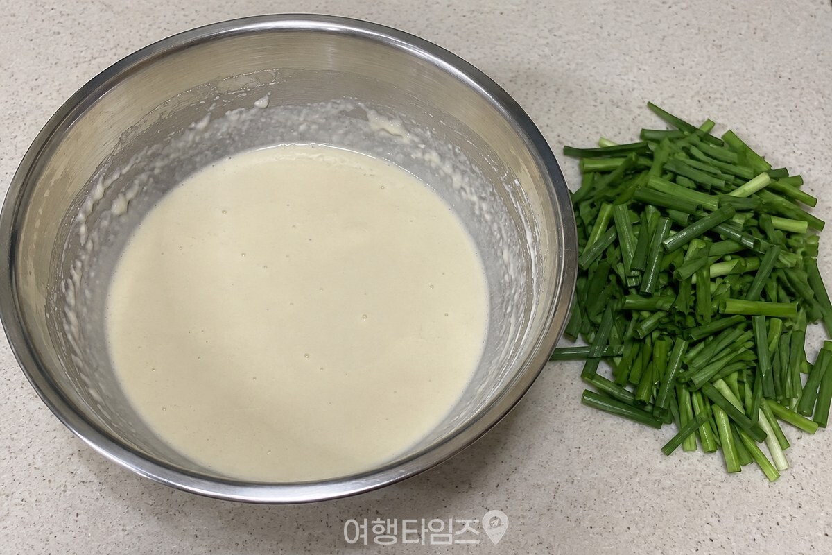 부침가루와 맹물을 섞은 볼 옆에 손질한 부추가 놓인 반죽 준비 장면. / 기사 이해를 돕기 위한 생성형 이미지