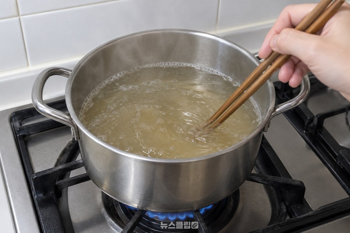 멸치가루를 푼 뒤 국물이 살짝 흐려진 냄비를 젓가락으로 젓는 모습. / 기사 이해를 돕기 위한 생성형 이미지