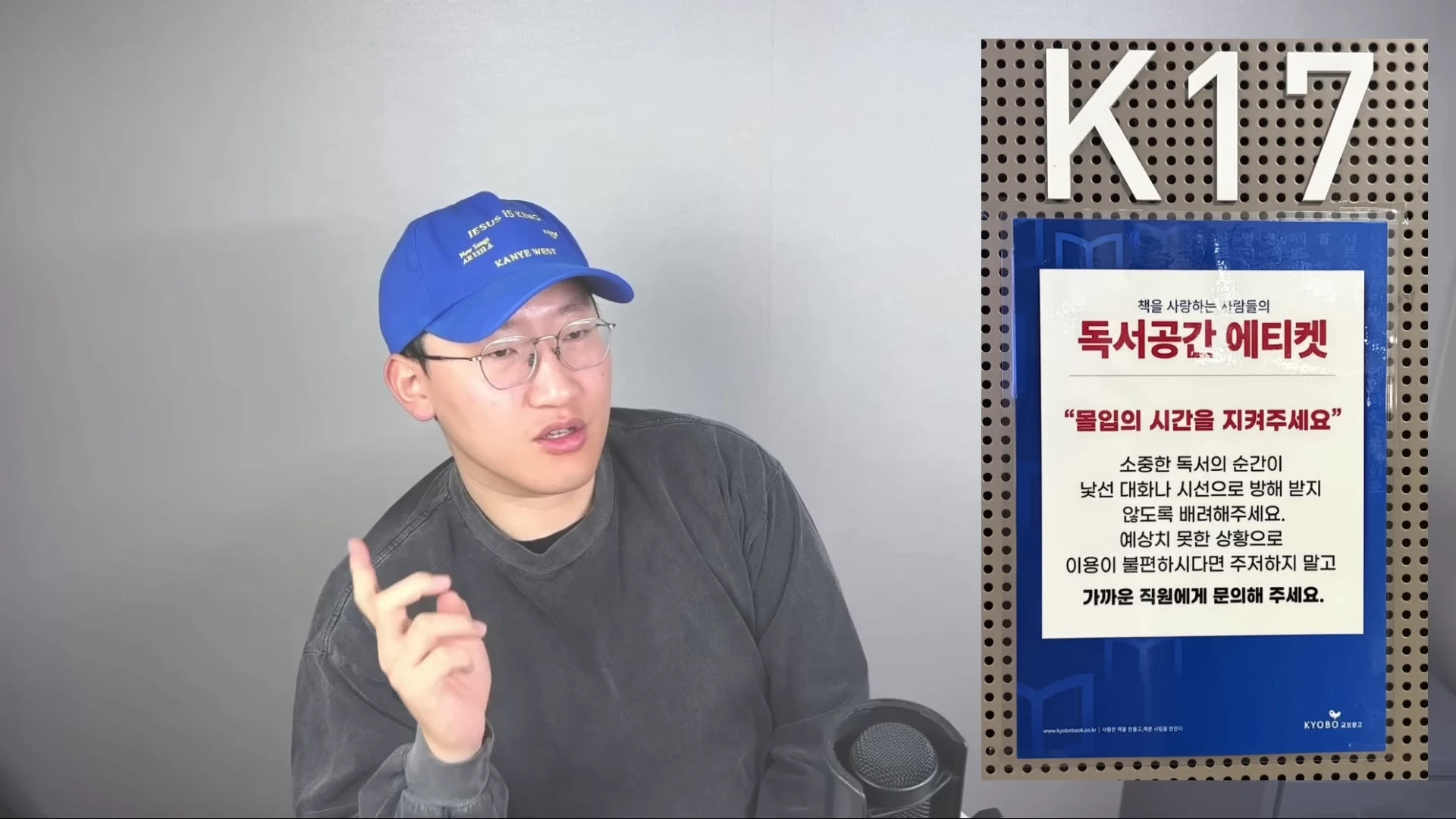 파란색 모자와 안경을 쓴 남성이 마이크 앞에서 이야기하고 있고, 오른쪽에는 독서 공간 에티켓에 관한 안내문이 크게 표시되어 있습니다.
