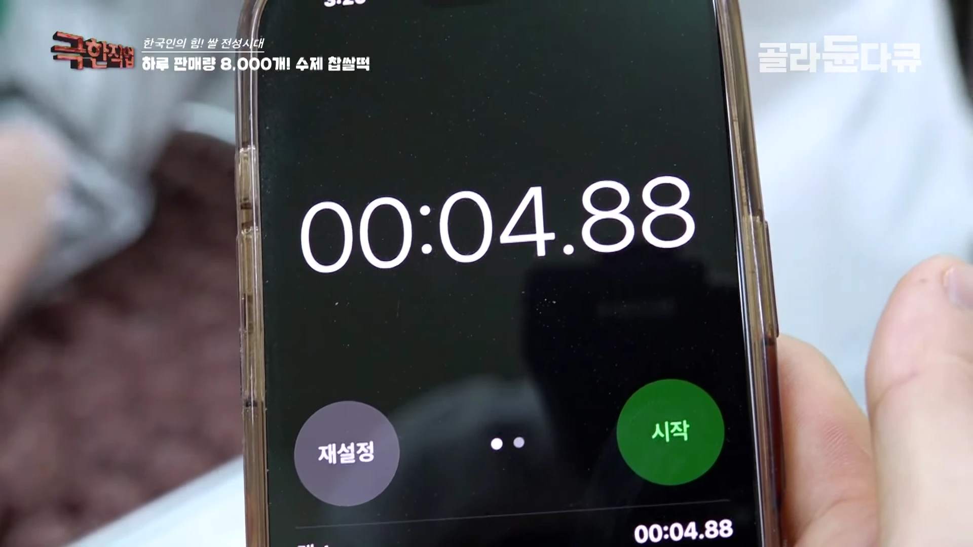 스마트폰 화면에 4초 88을 가리키는 스톱워치 애플리케이션이 실행되어 있으며, 그 위로 '하루 판매량 8,000개! 수제 찹쌀떡'이라는 자막이 표시되어 있습니다.