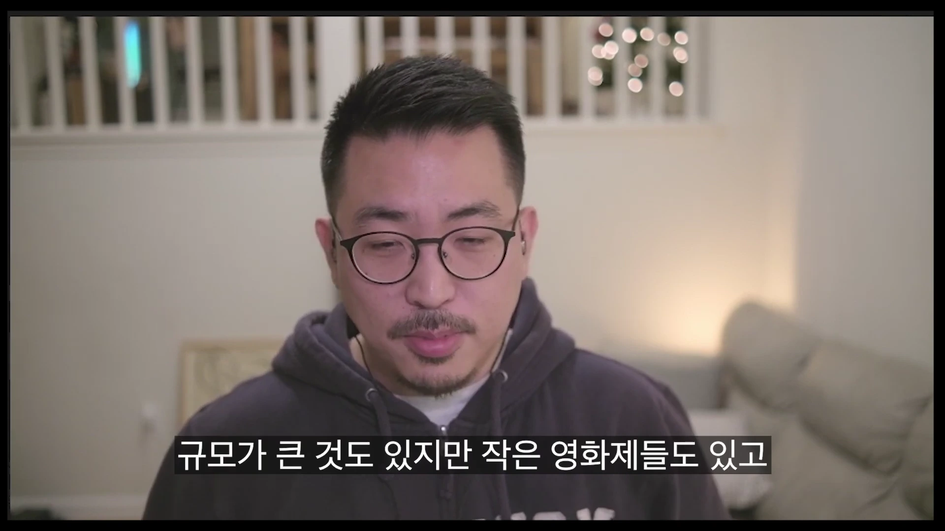 안경을 쓴 남성이 후드티를 입고 정면을 응시하며 이야기하고 있는 모습과 하단에 한국어 자막이 표시된 화면