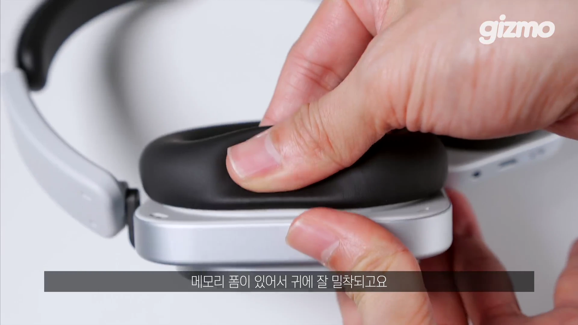 헤드폰의 이어패드를 손가락으로 눌러 탄성을 확인하는 모습이 담긴 클로즈업 영상 화면.