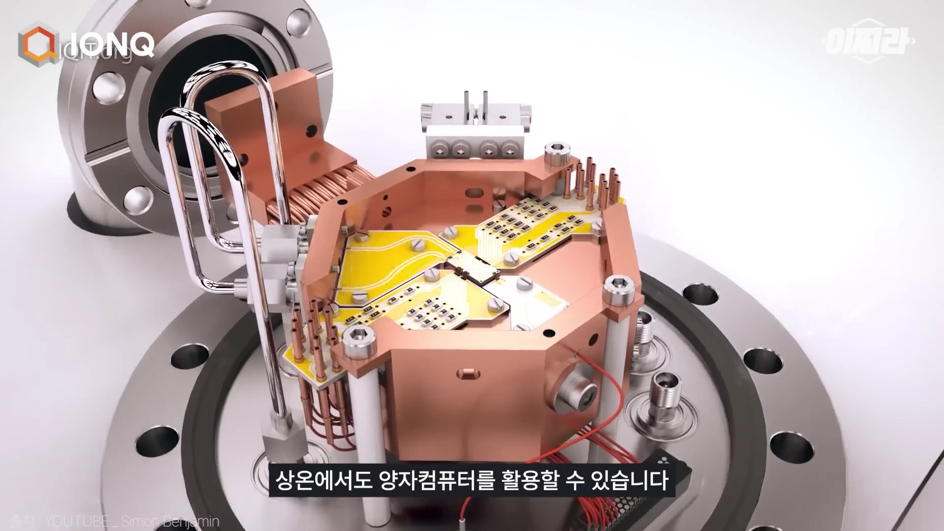 구리빛 금속 구조물 중앙에 노란색 회로 기판과 여러 개의 핀이 배치된 이온 트랩 양자 컴퓨터 내부 장치의 3D 그래픽 모델.