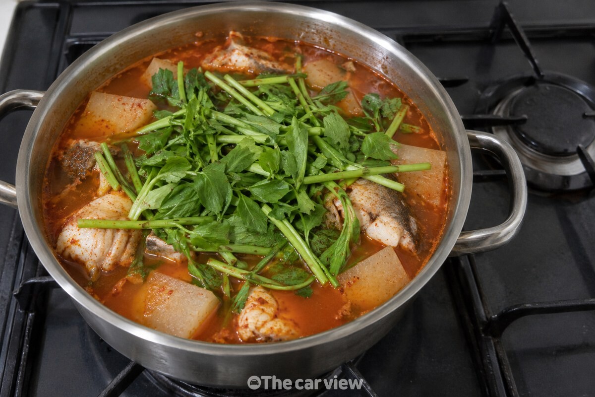 불을 끈 동태찌개 국물 위에 썰어 둔 미나리를 고르게 올린 모습 / 기사 이해를 돕기 위한 생성형 이미지