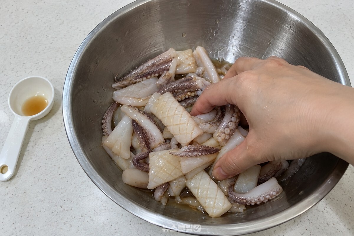 손질한 오징어에 멸치액젓과 매실액을 넣어 고루 버무리고 있다. / 기사 이해를 돕기 위한 생성형 이미지