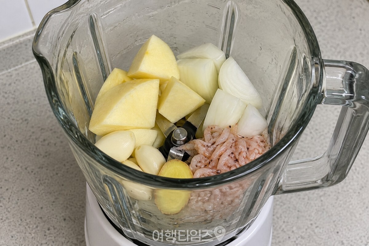껍질과 씨를 제거한 사과 반쪽을 양파·마늘·생강·새우젓과 함께 믹서에 넣은 모습. / 기사 이해를 돕기 위한 생성형 이미지