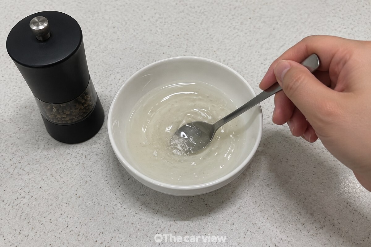 작은 그릇에서 소주와 소금을 숟가락으로 저어 밑간액을 만들고 있다. / 기사 이해를 돕기 위한 생성형 이미지