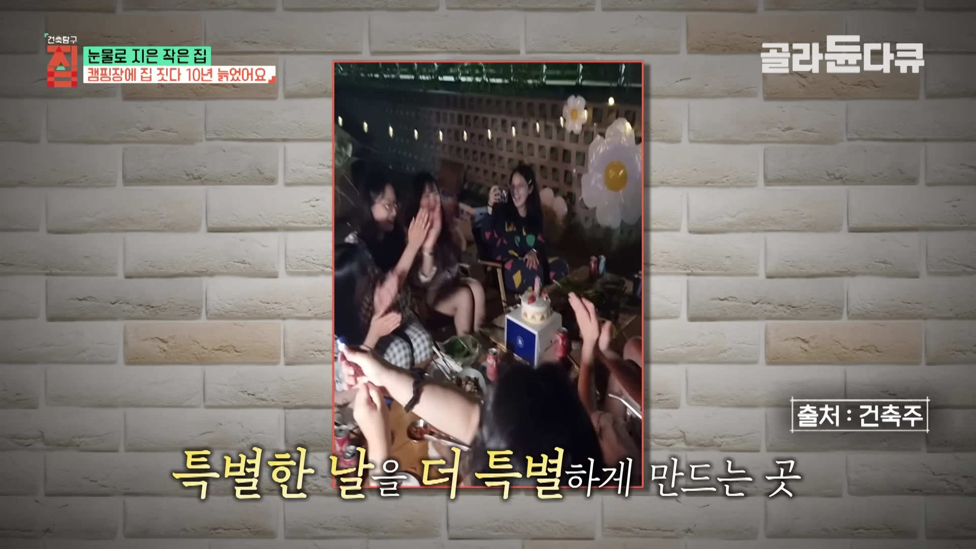 한밤중에 야외 공간에서 조명이 켜진 테이블에 둘러앉아 생일 파티를 즐기는 사람들의 모습이 담긴 사진