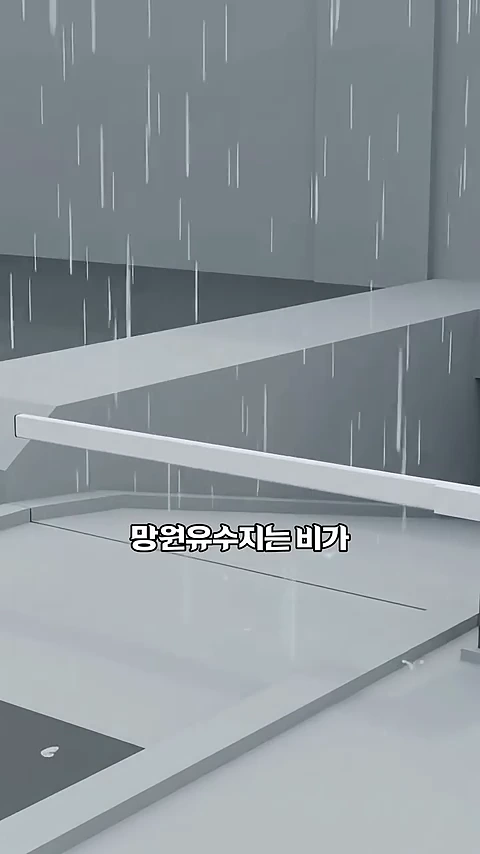 비가 내리는 모습을 단순하게 표현한 3D 그래픽 영상 속 화면으로, '망원유수지는 비가'라는 자막이 중앙에 적혀 있습니다.