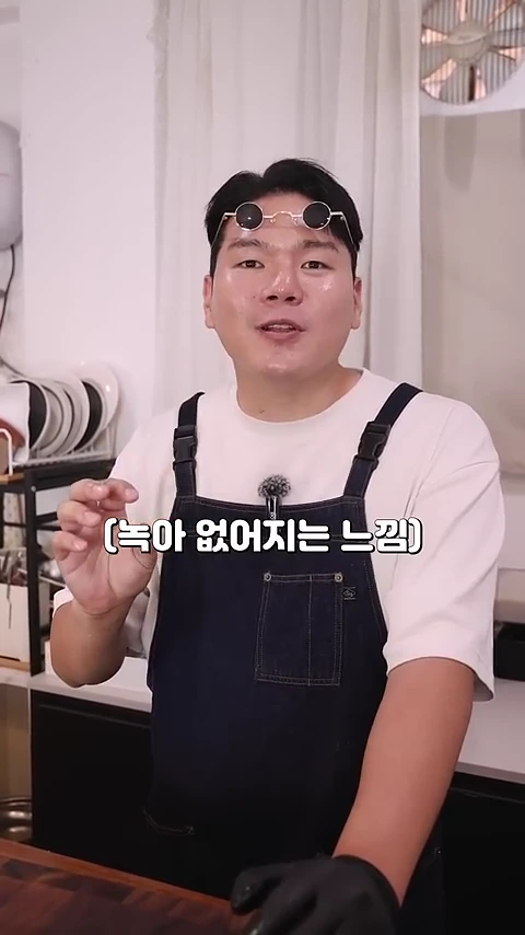 흰색 티셔츠와 검은색 앞치마를 착용한 남성이 요리 스튜디오에서 손짓하며 이야기를 나누고 있고, 화면 중앙에는 녹아 없어지는 느낌이라는 자막이 떠 있습니다.
