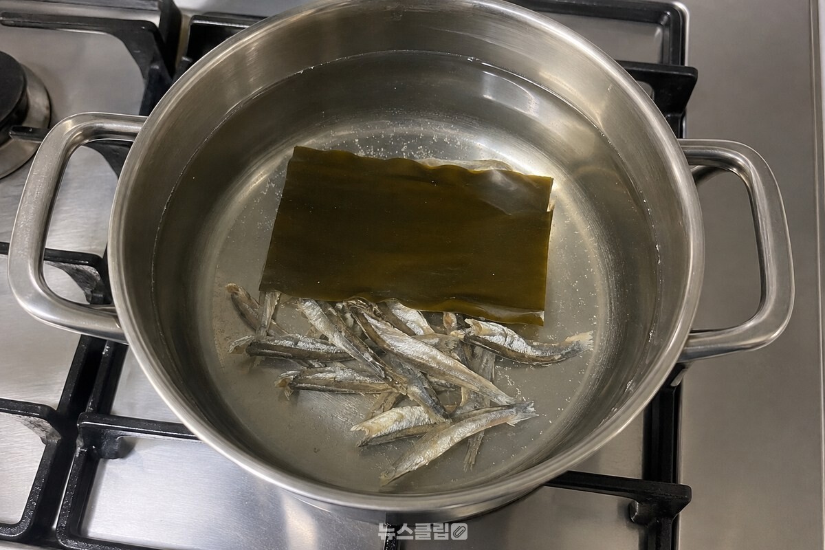 냄비의 맑은 밑국물에 다시마 한 장과 손질한 멸치가 담겨 있다. / 기사 이해를 돕기 위한 생성형 이미지