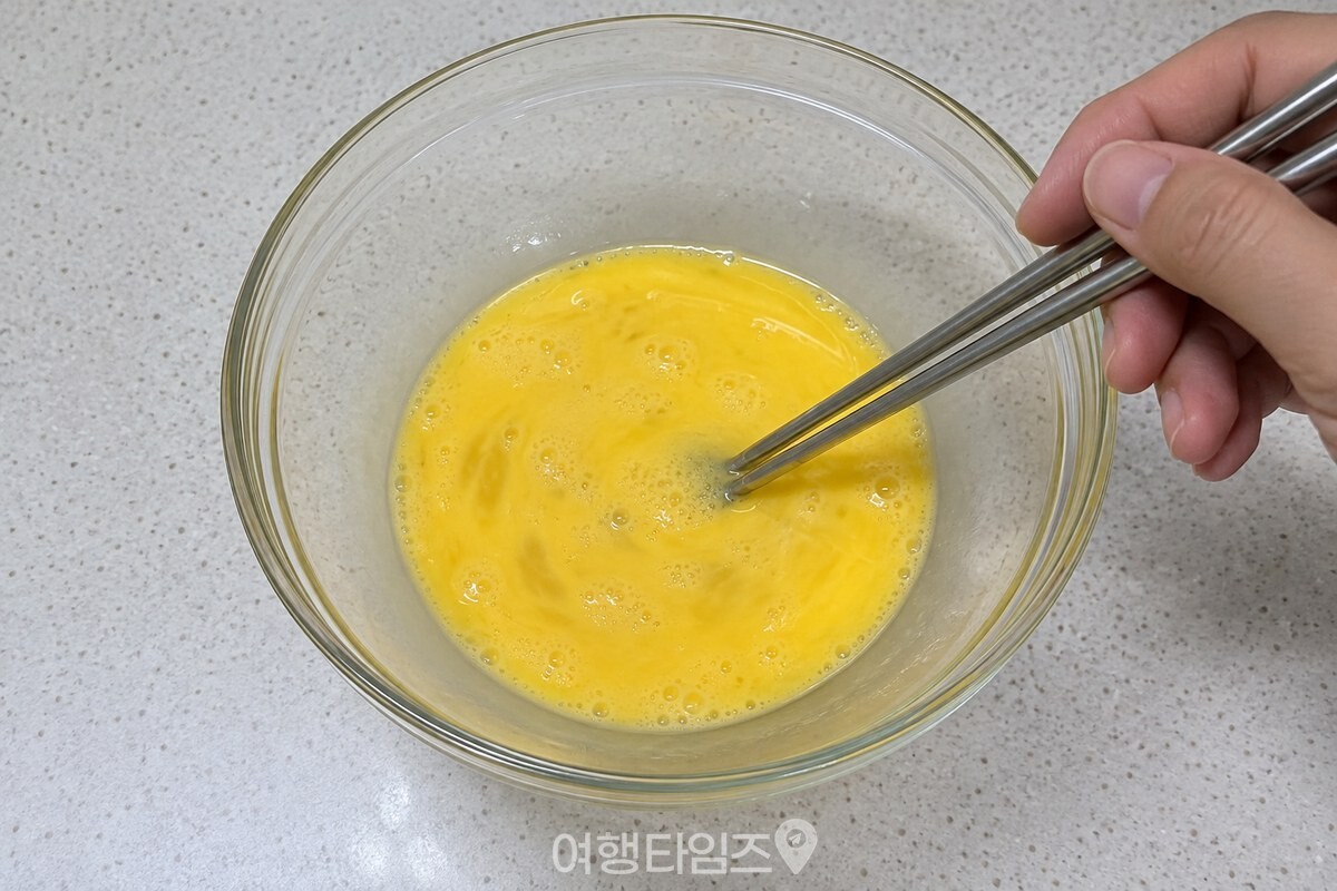 흰 계란물과 노른자가 투명 유리 그릇 안에서 고르게 풀려 있다. / 기사 이해를 돕기 위한 생성형 이미지