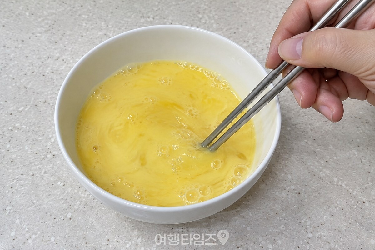 아주 연한 노란빛의 계란물을 젓가락으로 고르게 섞고 있다. / 기사 이해를 돕기 위한 생성형 이미지