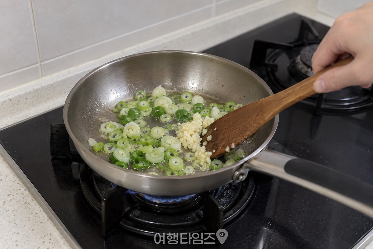 송송 썬 대파와 다진 마늘을 소량의 기름에 먼저 볶는 장면. / 기사 이해를 돕기 위한 생성형 이미지