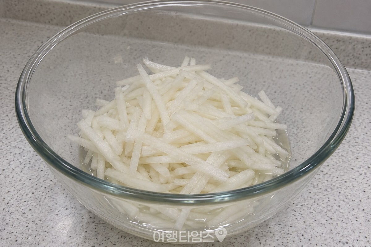 큰 유리 그릇 바닥에 무채에서 나온 맑은 물이 조금 고여 있다. / 기사 이해를 돕기 위한 생성형 이미지