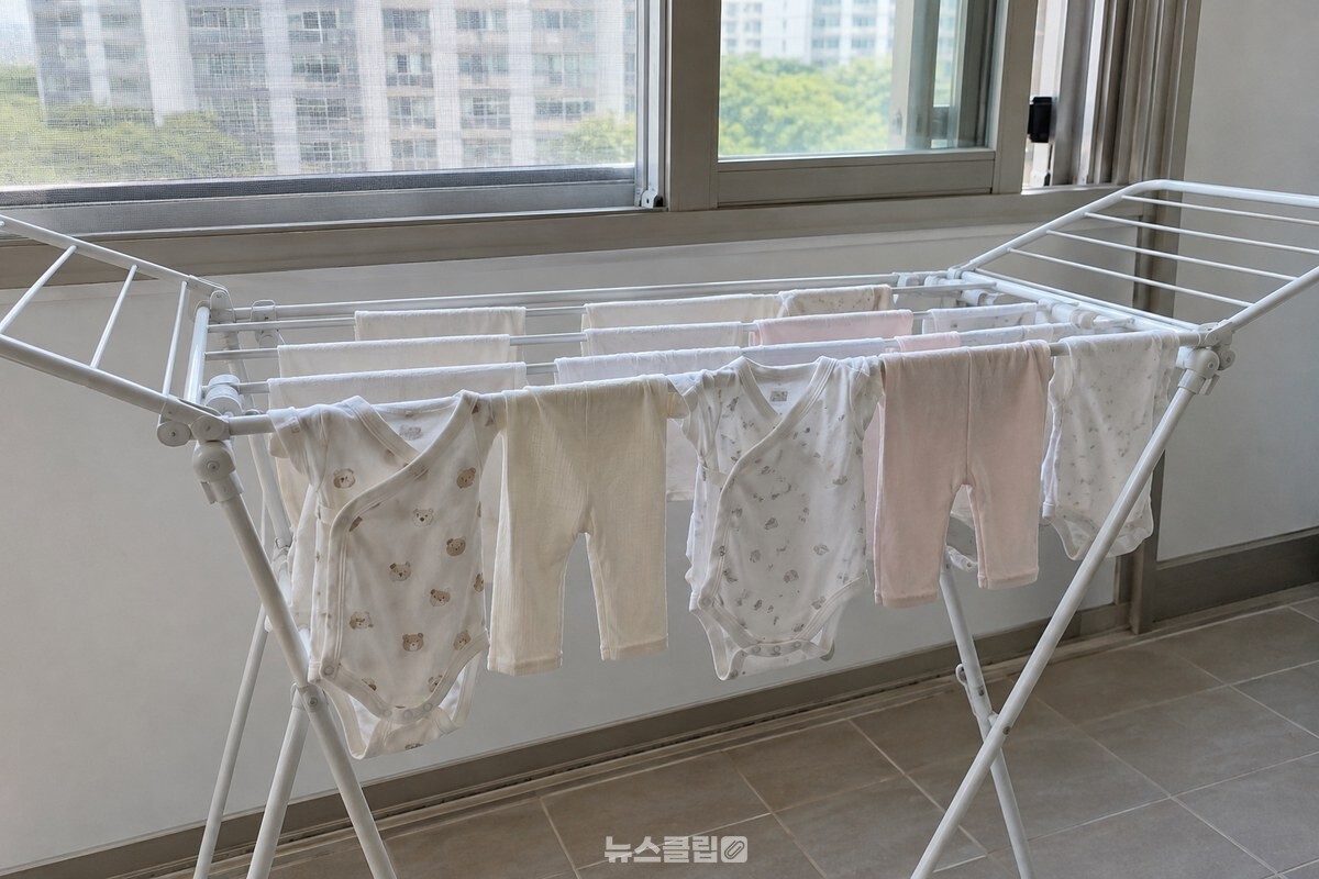 베란다의 흰색 접이식 건조대에 깨끗한 아기 옷을 넓게 펴서 말리고 있다. / 기사 이해를 돕기 위한 생성형 이미지