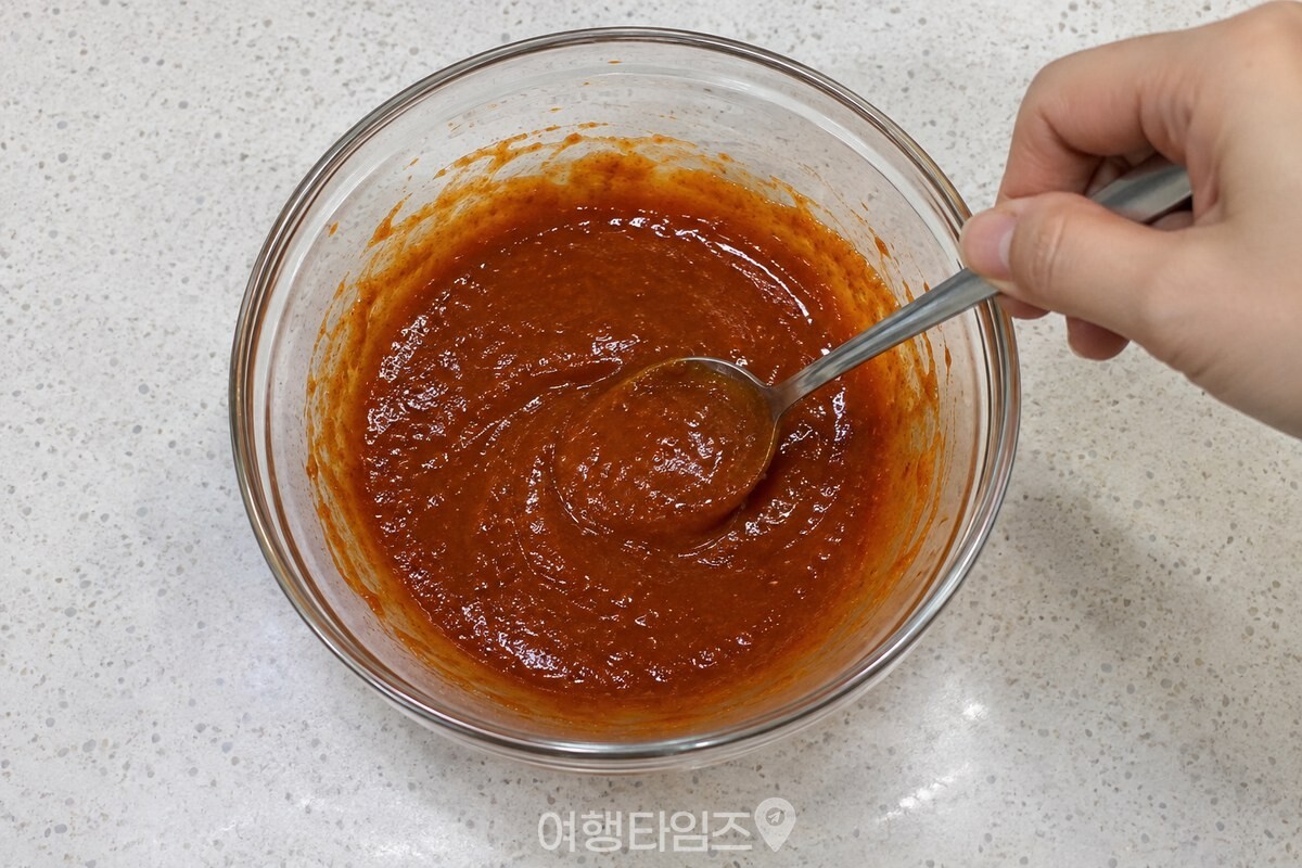 카레가루가 섞인 붉은 양념장을 숟가락으로 고르게 저어 주는 모습이다. / 기사 이해를 돕기 위한 생성형 이미지