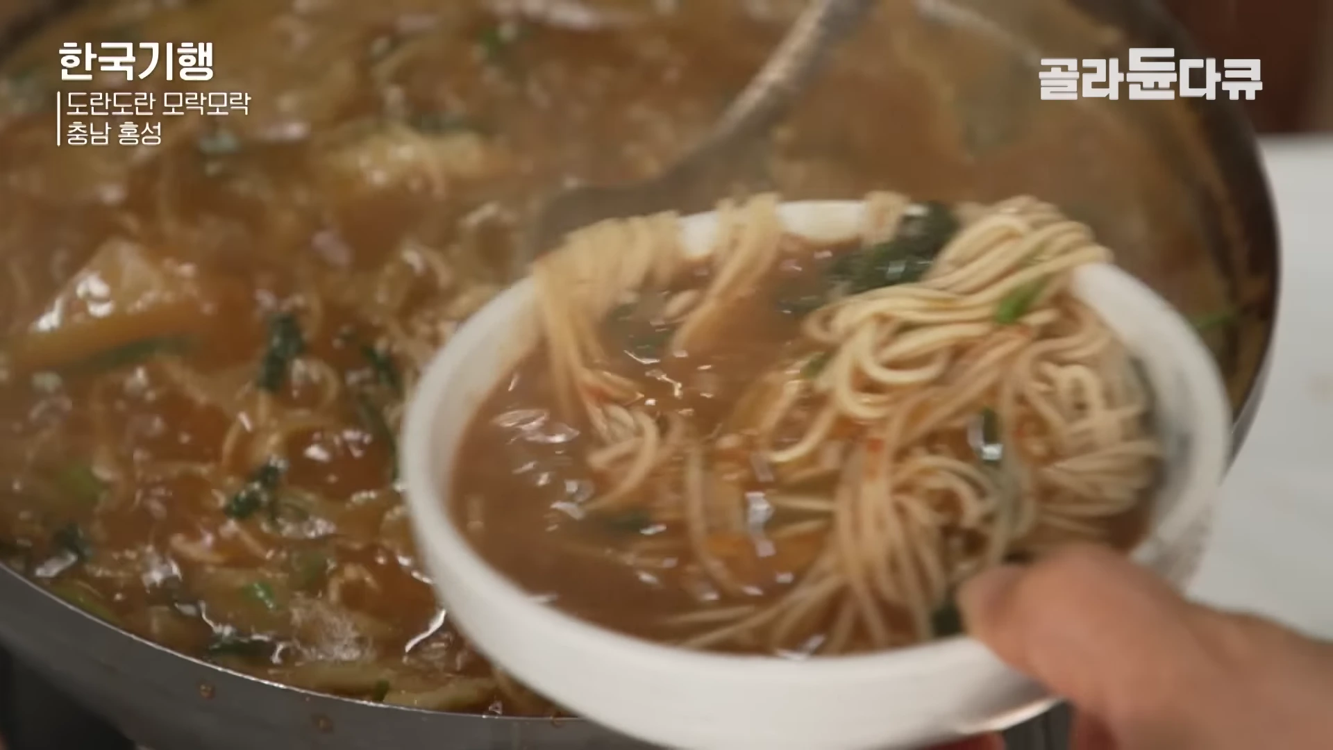 큰 냄비에 끓고 있는 어죽을 국자로 떠서 작은 그릇에 담아내는 모습