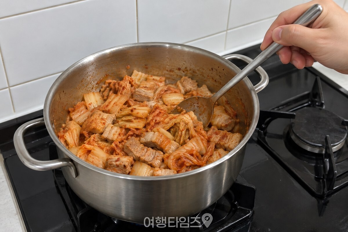 냄비에서 익은 삼겹살과 김치를 함께 볶는 조리 단계입니다. / 기사 이해를 돕기 위한 생성형 이미지