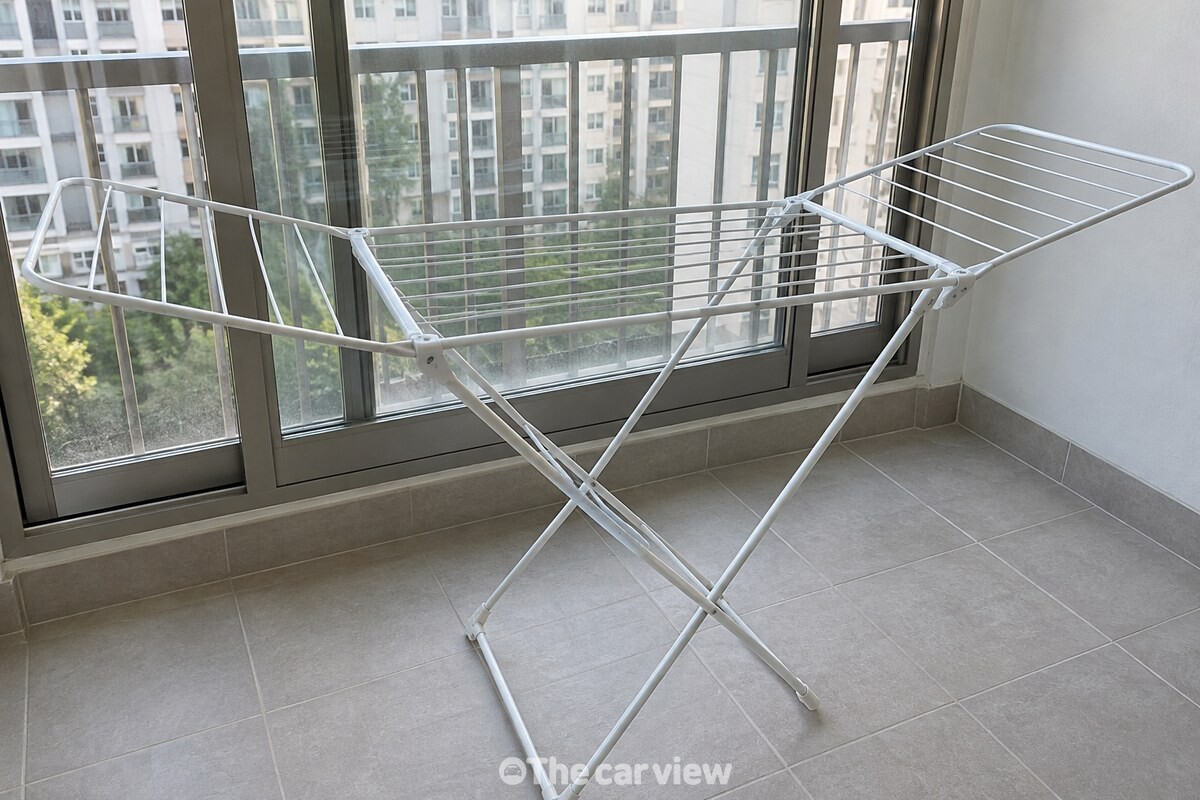 빨래를 걷은 뒤 펼쳐 둔 건조대가 열린 베란다 창가에서 마르고 있다. / 기사 이해를 돕기 위한 생성형 이미지