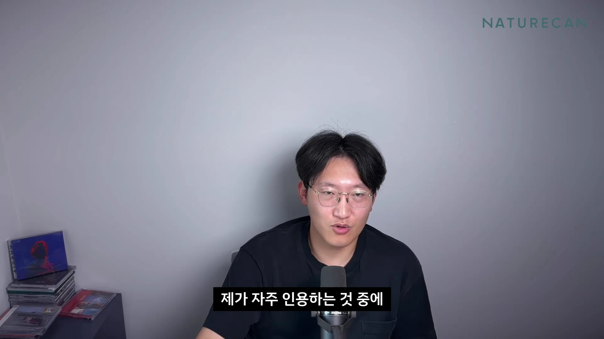 안경을 쓴 남성이 마이크 앞에 앉아 정면을 바라보며 이야기하고 있는 영상 화면, 하단에 자막이 표시되어 있다.