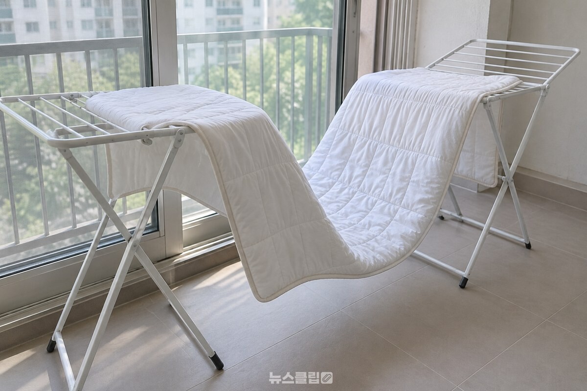 베란다의 건조대 두 개에 흰 여름 이불을 M자 모양으로 넌 장면 / 기사 이해를 돕기 위한 생성형 이미지
