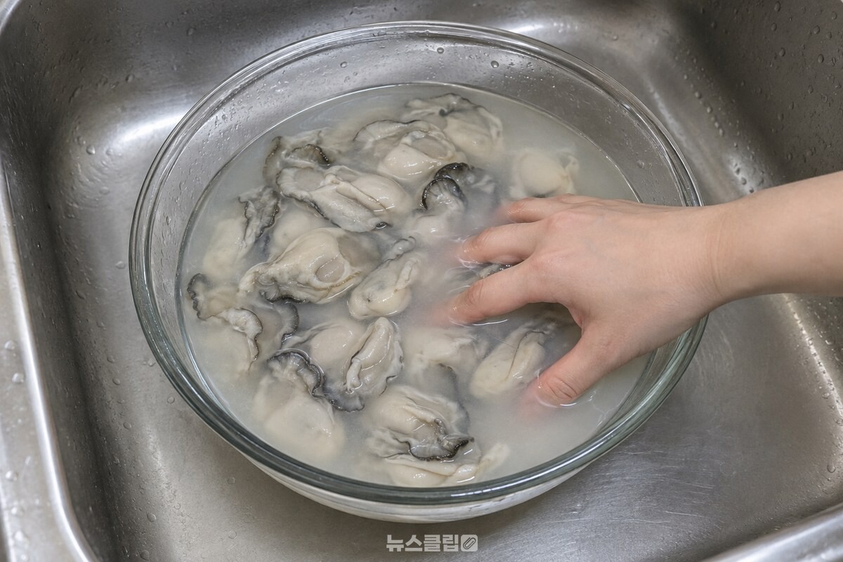 무즙 물에 담긴 굴을 손가락으로 가볍게 섞는 모습. / 기사 이해를 돕기 위한 생성형 이미지