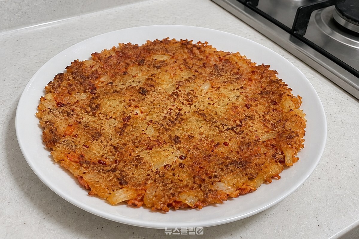 빵가루를 입혀 노릇하게 부친 김치전 한 장이 흰 접시 위에 놓여 있다. / 기사 이해를 돕기 위한 생성형 이미지
