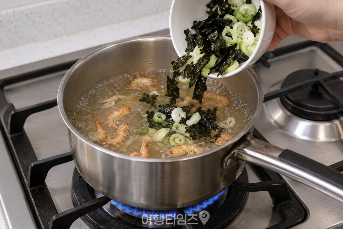 끓는 건새우 국물에 굵게 부순 김과 대파를 넣어 김국을 마무리하는 모습. / 기사 이해를 돕기 위한 생성형 이미지