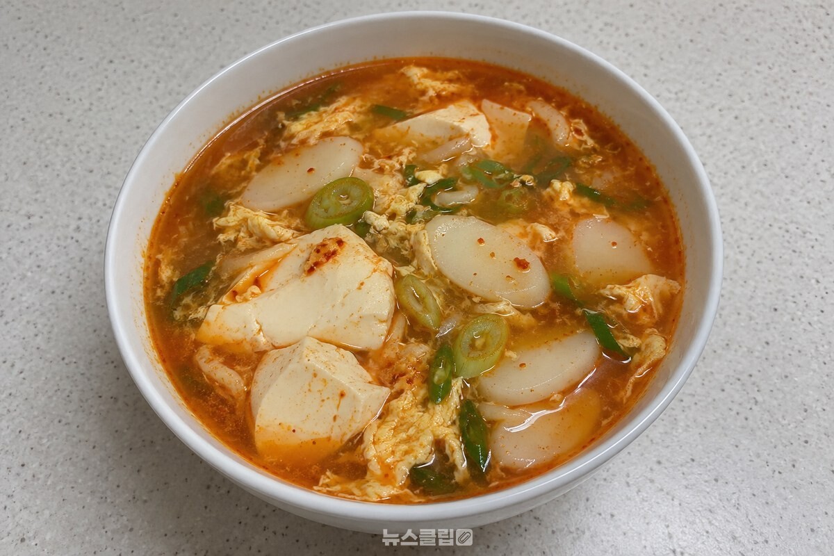 붉은 국물에 떡국떡과 큼직한 순두부, 달걀과 대파가 담긴 떡국 한 그릇. / 기사 이해를 돕기 위한 생성형 이미지