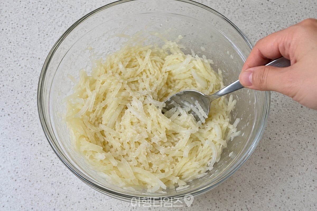 물기를 뺀 감자와 양파 반죽에 소금을 넣어 고루 섞고 있다. / 기사 이해를 돕기 위한 생성형 이미지