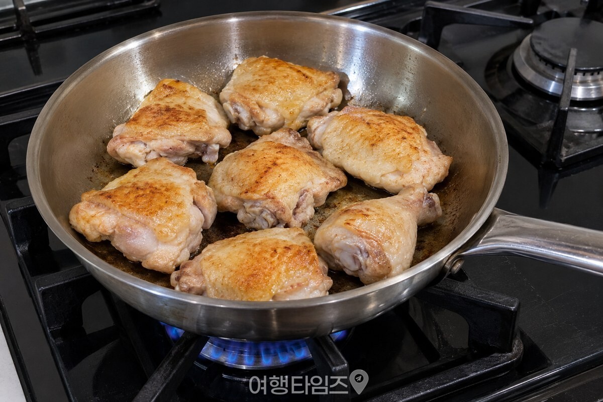 두꺼운 팬에 닭고기를 껍질 쪽으로 한 겹 펼쳐 노릇하게 굽는 모습. / 기사 이해를 돕기 위한 생성형 이미지