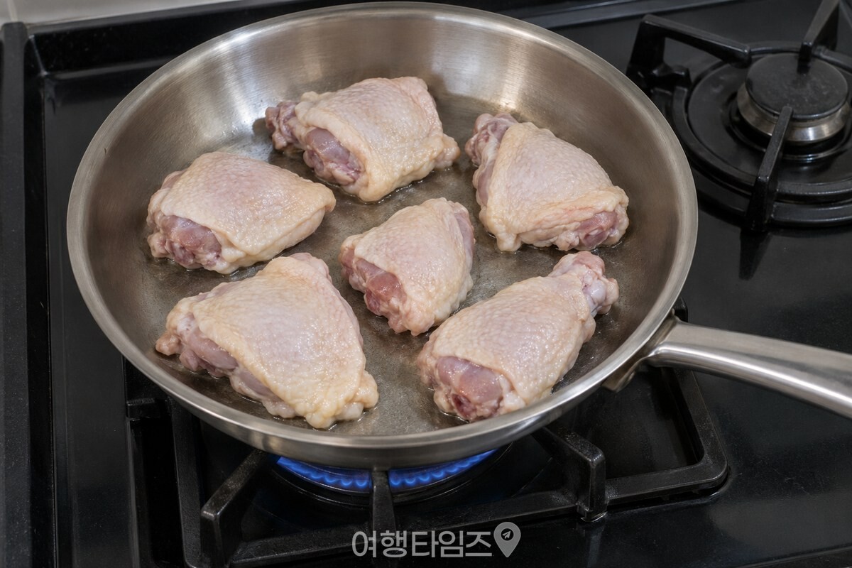 기름 없이 팬에 닭고기를 한 겹으로 펼쳐 놓고 처음 면을 익히는 모습. / 기사 이해를 돕기 위한 생성형 이미지