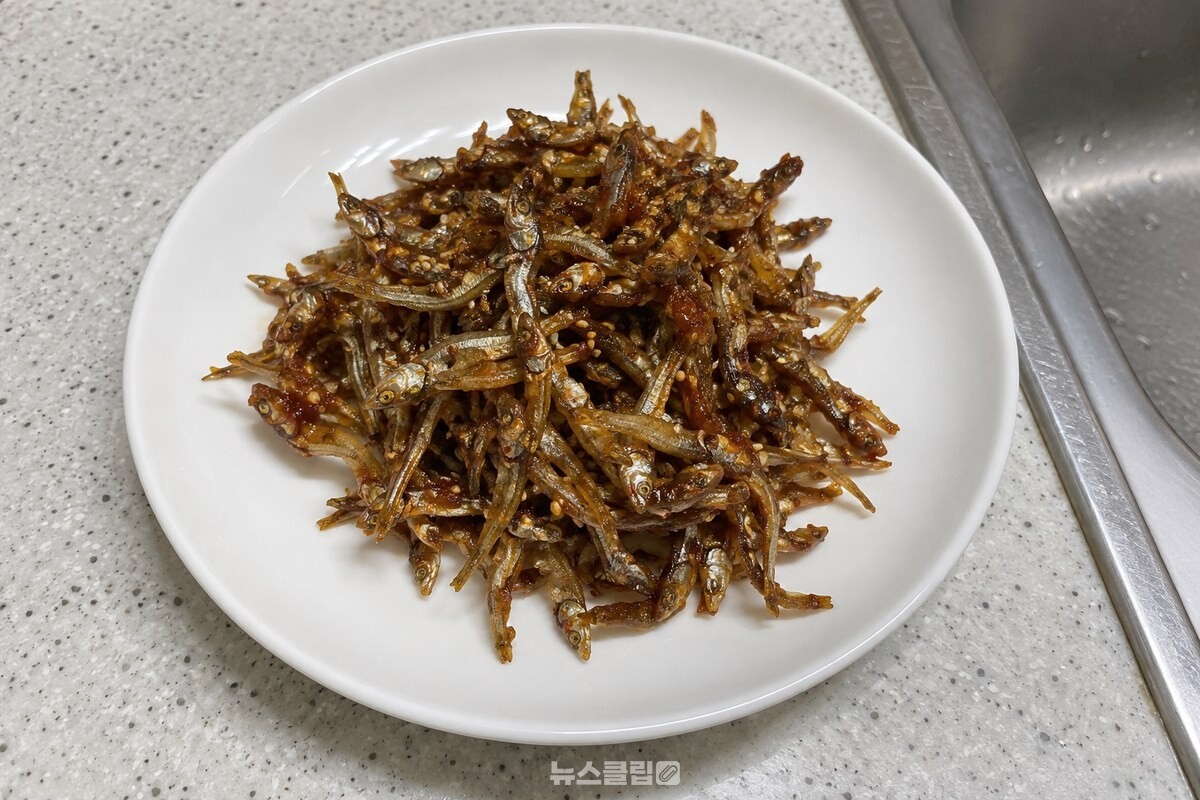 넓은 흰 접시에 쌈장 양념이 얇게 묻은 잔멸치볶음이 담겨 있다. / 기사 이해를 돕기 위한 생성형 이미지