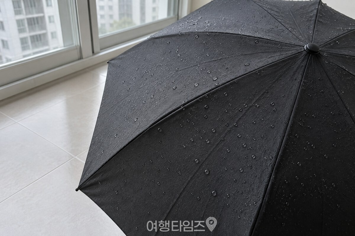 펼친 검은 천 우산의 한 폭에 물방울이 둥글게 맺힌 표면이 가까이 보인다. / 기사 이해를 돕기 위한 생성형 이미지