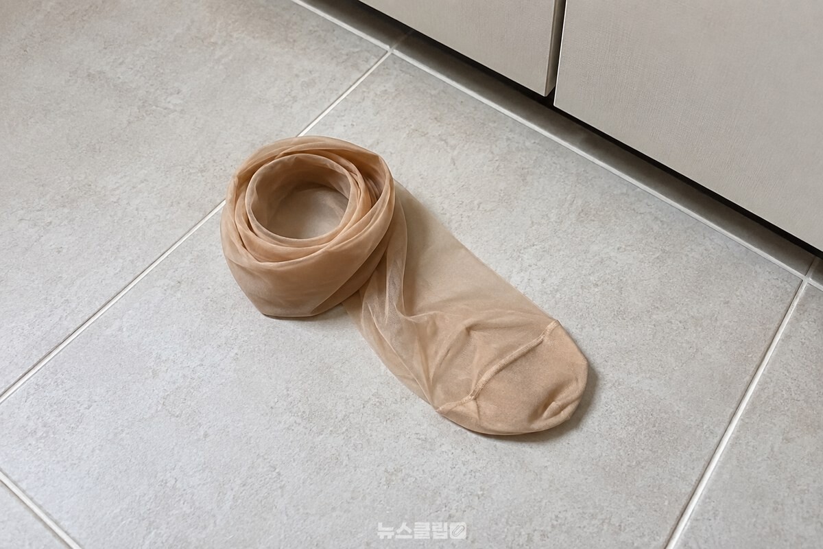 깨끗한 손으로 스타킹을 발목 부분까지 말아 발끝에 끼우는 모습. / 기사 이해를 돕기 위한 생성형 이미지