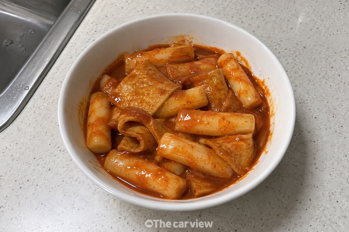 흰 그릇에 담긴 떡볶이에 걸쭉한 붉은 양념이 고르게 묻어 있다. / 기사 이해를 돕기 위한 생성형 이미지