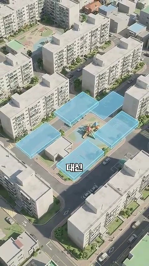 주거 단지의 항공뷰 이미지로, 중앙 놀이터 주변의 빈 공간에 반투명한 하늘색 직사각형 도형들이 배치되어 있으며 '대신'이라는 한글 자막이 중앙에 표시되어 있다.